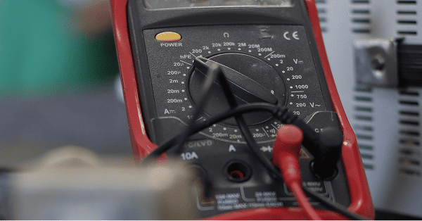 Électricien à Fougères vérifiant une installation électrique au multimètre